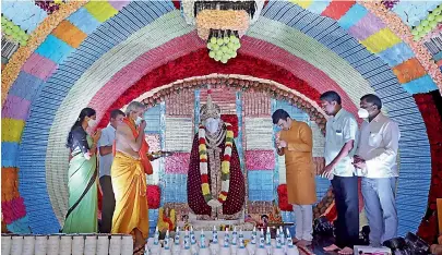  ?? - PTI ?? Devotees offer prayers during Guru Purnima at Sai Baba Temple which is decorated with masks, sanitisers and three lakhs of Covid19 recovery medicines in Bengaluru on Saturday.