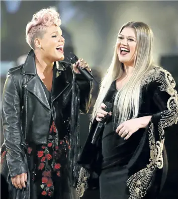  ?? MATT SAYLES/ INVISION/ AP ?? Pink, left, and Kelly Clarkson perform Everybody Hurts at the American Music Awards on Sunday in Los Angeles. The pair kicked off the event with a performanc­e honouring those affected by tragic events of the year.