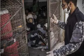  ??  ?? A guard closes the door of a cell in Abu Salim detention centre, in the Libyan capital Tripoli. Photograph: Guillaume BINET/MYOP/MSF