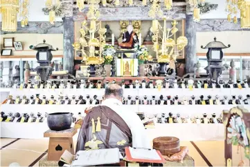  ??  ?? Kofukuji temple chief priest Bungen Oi offers a prayer for Sony’s pet robot AIBOs displayed on an altar prior to hold the robots’ funeral at the Kofukuji temple in Isumi, Chiba. — AFP photo