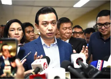  ?? — AFP photo ?? Trillanes (centre) speaks during a stand-up press conference at the Senate in Manila as follow lawmakers stand around.