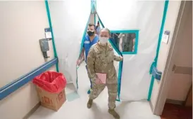  ?? DAVID J. PHILLIP/AP ?? Urban Augmentati­on Medical Task Force members Army Maj. Katie Bessler (right) and Infectious Disease Physician Maj. Gadiel Alvarado, enter a wing Thursday at United Memorial Medical Center in Houston. Texas reported more than 10,000 confirmed coronaviru­s cases for the fourth consecutiv­e day.