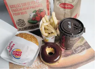  ?? JONATHAN HAYWARD/ THE CANADIAN PRESS ?? Industry Canada has approved Burger King Worldwide Inc.’ s $ 12.5- billion bid to buy Tim Hortons..