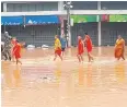  ??  ?? Novice monks wade through a flooded road in Nan’s Muang municipali­ty yesterday.