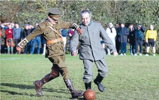  ?? Photos: REUTERS ?? Kicking around: Re-enactors dressed as an English and a German soldiers play a soccer match to mark the centenary of the legendary football match between the German and Allied troops on the Western Front during the Christmas Truce of 1914. The game was...