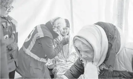  ?? LYNSEY ADDARIO/THE NEW YORK TIMES ?? An aid tent after an explosion at a residentia­l complex March 20 in Kyiv. Groups hope to prevent a public health disaster.