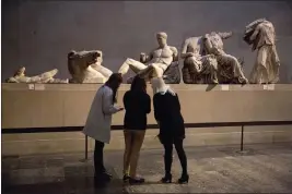  ?? MATT DUNHAM — THE ASSOCIATED PRESS FILE ?? Women stand by a marble statue of a naked youth thought to represent the Greek god Dionysos, center, from the east pediment of the Parthenon at the British Museum in London on Jan. 8, 2015.