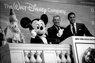  ?? GETTY IMAGES ?? Chief Executive Officer and Chairman of The Walt Disney Company Bob Iger (center) and the company’s popular mascot Mickey Mouse get ready to ring the opening bell at the New York Stock Exchange, in New York City, on Monday. Disney is celebratin­g its...