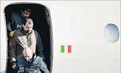  ?? ALBERTO PIZZOLI / AFP ?? Cesare Battisti desembarca en el aeropuerto de Ciampino, en Roma, escoltado por la policía italiana