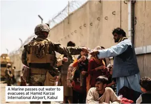  ??  ?? A Marine passes out water to evacuees at Hamid Karzai Internatio­nal Airport, Kabul