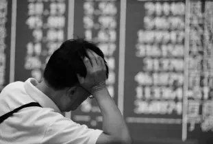  ??  ?? An investor rests on his arm before a screen that shows share prices at a securities firm in Hangzhou, east China’s Zhejiang Province. — AFP Photo