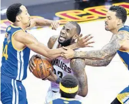  ?? JASON MILLER/GETTY IMAGES ?? LeBron James, who tallied a triple double with 31 points, 10 rebounds and 11 assists, drives to the basket against Golden State’s Shaun Livingston and Matt Barnes.