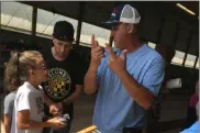  ?? RICHARD PAYERCHIN — THE MORNING JOURNAL ?? Todd Clement, right, explains how to release a homing pigeon at the Lorain County Fair on Aug. 24.