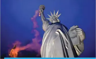  ??  ?? BONN: Photo shows a replica of the Statue of Liberty emitting smoke from the torch created by Danish artist Jens Galschiot and displayed at the Rheinaue park during the COP23 United Nations Climate Change Conference in Bonn. —AFP