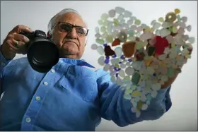  ?? ROBERT F. BUKATY — THE ASSOCIATED PRESS ?? Donald Verger arranges sea glass in the shape of a heart, Thursday, Feb. 11, in Falmouth, Maine. After photograph­ing his art, Verger donates photos and cards to schools and hospitals as a way of giving back during the pandemic.