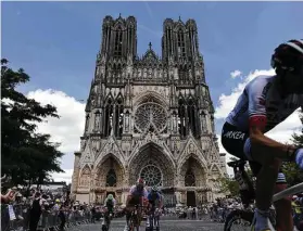  ?? Jeff Pachold / AFP/Getty Images ?? Reims Cathedral, constructe­d in 1211, serves as a historic backdrop for cyclists competing in Monday’s third stage between Binche and Epernay.