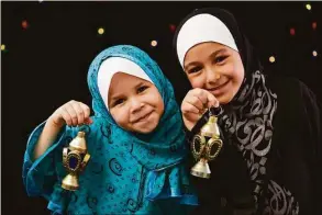  ?? Dreamstime ?? Muslim girls with Ramadan lanterns.