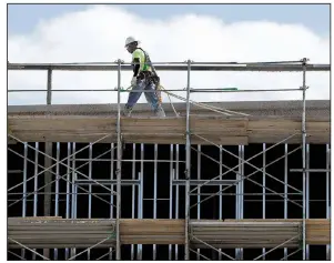  ?? AP ?? Workers build an apartment and retail complex in Nashville, Tenn., in October. The Commerce Department said Wednesday that private constructi­on spending was up 1 percent in November.