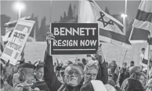  ?? AFP VIA GETTY IMAGES ?? A man holds up a sign during an anti-government protest by Israeli right-wing supporters in Jerusalem on Wednesday.