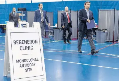  ?? GREG LOVETT/THE PALM BEACH POST ?? Gov. Ron DeSantis walks with Florida Division of Emergency Management Director Kevin Guthrie, left, FDEM Chief Medical Officer Dr. Kenneth Scheppke and state Sen. John Snyder during a visit to a treatment site in West Palm Beach on Thursday.