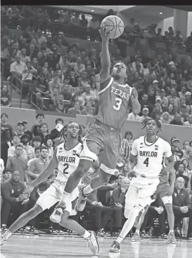  ?? ROD AYDELOTTE/WACO TRIBUNE-HERALD ?? Texas guard Max Abmas scores between Baylor guards Jayden Nunn, left, and Ja’Kobe Walter during their March 4 game in Waco. The Longhorns secured a No. 7 seed in this year’s NCAA Tournament.