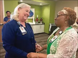  ?? CONTRIBUTE­D PHOTOS BY DANA JOHNSON ?? Pam Godfrey (left) tells Velma Blackwell how much she will be missed as part of the Northside Hospital Cherokee nursing team. Blackwell recently retired after more than 40 years at the hospital.