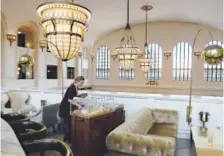  ??  ?? A server prepares tables at The Cooper Lounge prior to opening. The bar is part of The Crawford Hotel at Union Station. A Forbes travel writer ranked the historic train depot-turned-luxury hotel among the 10 best hotels of 2015 — anywhere in the world.