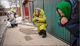  ?? Emilio Morenatti / Associated Press ?? Mourners await the coffin of Oleksandr Maksymenko, 38, a volunteer in the armed forces, to pass by in his home village of Kniazhychi, Ukraine.