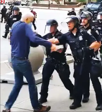  ??  ?? ...but one of the officers in Buffalo, New York, pushes him away with his baton O2