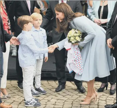  ??  ?? FLOWER BOY: The Duchess of Cambridge receives a bouquet as she arrives to tour a cycling themed festival in Place de Clairefont­aine.