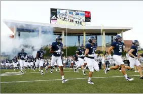  ?? MATT PATTERSON — THE ASSOCIATED PRESS ?? Rice University football players run onto the field for a 2019 game in Houston.
