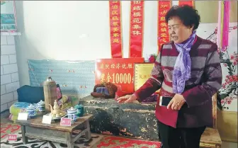  ?? ZHANG YI / CHINA DAILY ?? Li Hongxiu, the owner of a folk museum dedicated to the history of the Huerjia, displays a kang, or brick bed, used by Cao Guangyou, a third-generation Huerjia.