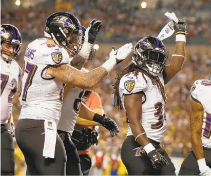  ?? JUSTIN K. ALLER/GETTY IMAGES ?? Running back Alex Collins, right, of the Ravens celebrates after a 3-yard touchdown reception in the first quarter against the Steelers at Heinz Field. Joe Flacco threw for 363 yards and two touchdowns.