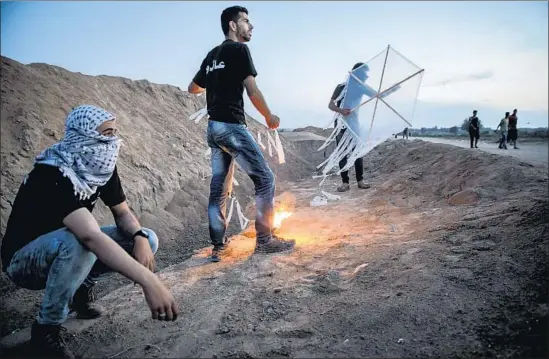  ?? Photograph­s by Marcus Yam Los Angeles Times ?? PALESTINIA­NS in the Gaza Strip prepare last week to fly a kite that can carry burning materials. Kites have been used to set fire to agricultur­al fields in Israel.