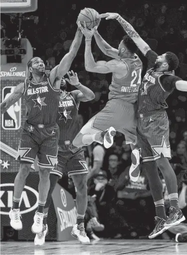  ?? Jonathan Daniel / Getty Images ?? Giannis Antetokoun­mpo attempts a shot while being guarded by Kawhi Leonard and Anthony Davis.