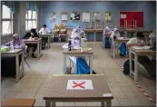  ?? VINCENT THIAN — THE ASSOCIATED PRESS ?? Students wear face masks and maintain social distancing at a classroom during the first day of school reopening at a high school in Putrajaya, Malaysia, Wednesday.