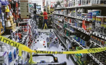  ?? Photos by Dan Joling / Associated Press ?? An employee walks past a damaged aisle at Anchorage True Value hardware store after Friday’s earthquake. Tim Craig, owner of the south Anchorage store, said no one was injured but hundreds of items hit the floor.