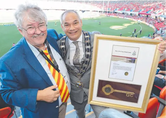  ?? Picture: MIKE BATTERHAM ?? Former Bulletin editor Bob Gordon receives the Keys to the City from Mayor Tom Tate at Metricon Stadium yesterday.