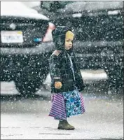  ?? Gina Ferazzi Los Angeles Times ?? JOAN HAVENS, 2, of Phelan walks through the first snowfall of the season in Wrightwood, Calif. Up to 2 feet could accumulate in the resort community.