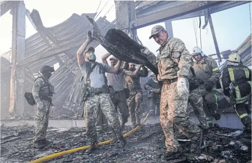  ?? REUTERS ?? Rescuers work at the site of a shopping mall hit by a Russian missile strike in Kremenchuk, Poltava region on Monday.