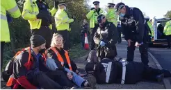  ?? ?? Line-up... Most of the 32 Insulate Britain activists who have been, or expect to be, taken to court; left, Tuesday’s demo at M25/A1 junction