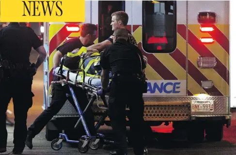  ?? IAN KUCERAK / POSTMEDIA ?? A so-called lone-wolf terrorist is believed to be responsibl­e for injuring an Edmonton police officer and several pedestrian­s in an attack using multiple vehicles and a knife. One of the injured is loaded onto an ambulance outside The Pint bar in...