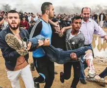  ?? AFP ?? Palestinia­ns carry away a protester injured during clashes following a demonstrat­ion near the Gaza border yesterday.