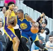  ?? Ethan Miller Getty Images ?? KEVIN DURANT of the Golden State Warriors drives the ball against the Lakers’ Brandon Ingram.