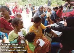  ??  ?? SUKARELAWA­N perubatan melakukan pemeriksaa­n kesihatan.