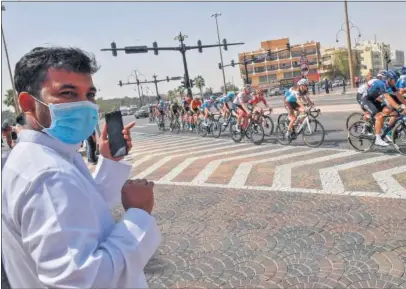  ??  ?? Un espectador con mascarilla presencia el pasado UAE Tour de los Emiratos Árabes Unidos.