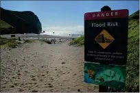  ?? ?? A flood warning sign alerts visitors to Tennessee Beach of the possibilit­y of flooding below an earthen dam in the Golden Gate National Recreation Area.