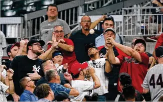  ?? JOHN BAZEMORE/ASSOCIATED PRESS ?? Fans reach for a foul ball during a game between the Braves and Yankees on Aug. 23 at Truist Park. The game drew 39,176, more than 10,000 above the Braves’ average this season.