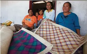  ??  ?? Women from the Maliangin Island Community Associatio­n weave mats and other souvenirs from pandanus leaves to reduce pressure on fisheries.