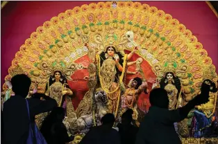  ?? (AP/Bikas Das) ?? People offer prayers Sunday at a makeshift worship venue on the first day of Durga Puja festival in Kolkata, India.